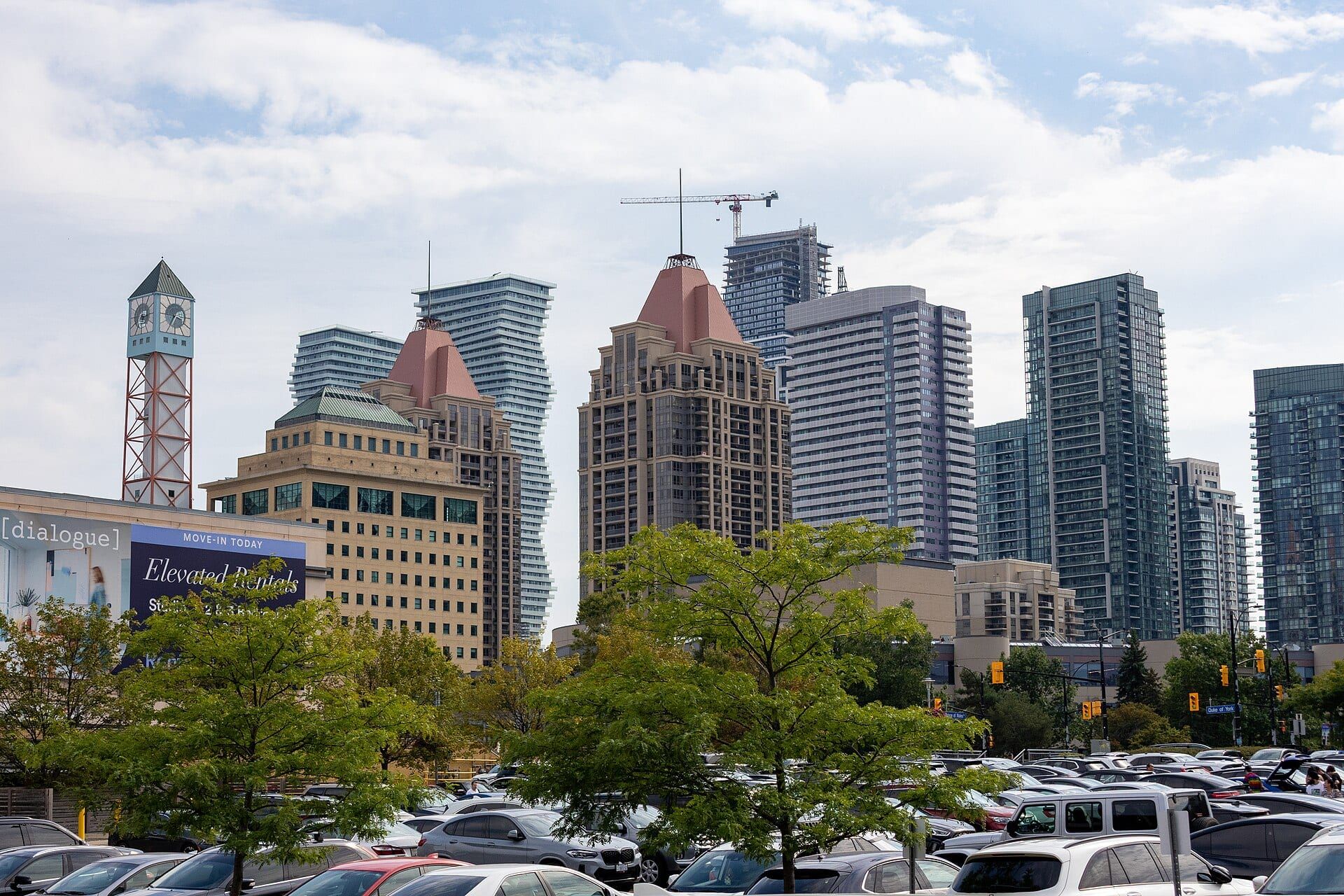 Condo towers and the clock tower of the Mississauga City Centre skyline on a partly cloudy day.