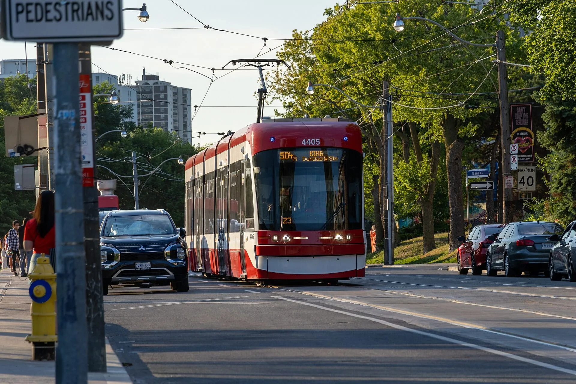 A red TTC streetcar on tree-lined Broadview Avenue near Withrow Avenue in Riverdale, Toronto.